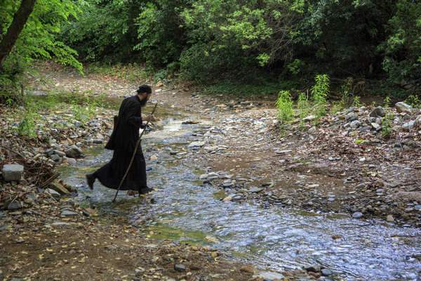 Монах переходит через ручей фото