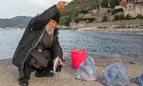 Монах рыбачит у монастыря Ксенофонт фото