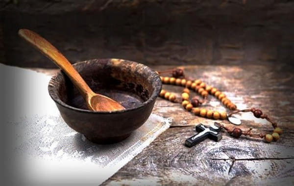 Тарелка с ложкой и четки на столе фото